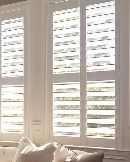 Luxury white indoor plantation shutters in bedroom - selective focus.