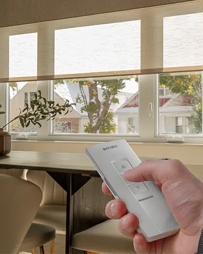 hand holding remote control adjusting blinds
