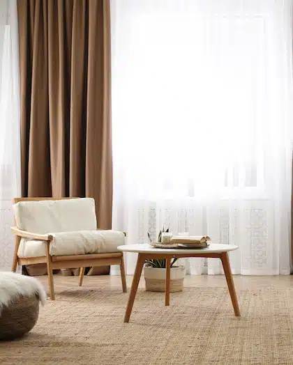 Modern furniture and window with curtains in stylish room interior