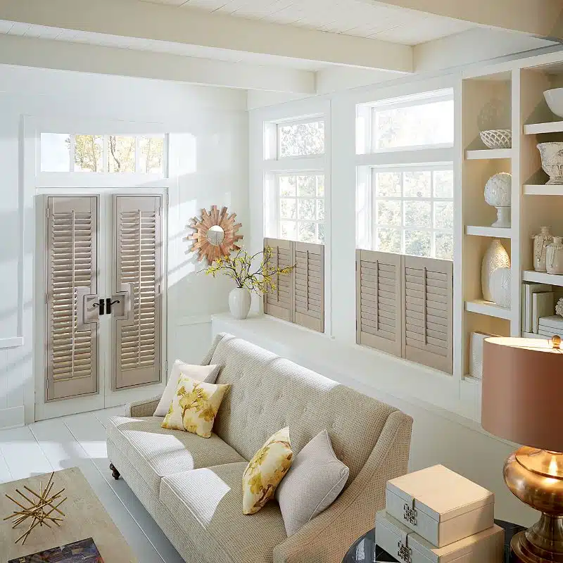 natural wood shutters on bottom half of windows in a living room